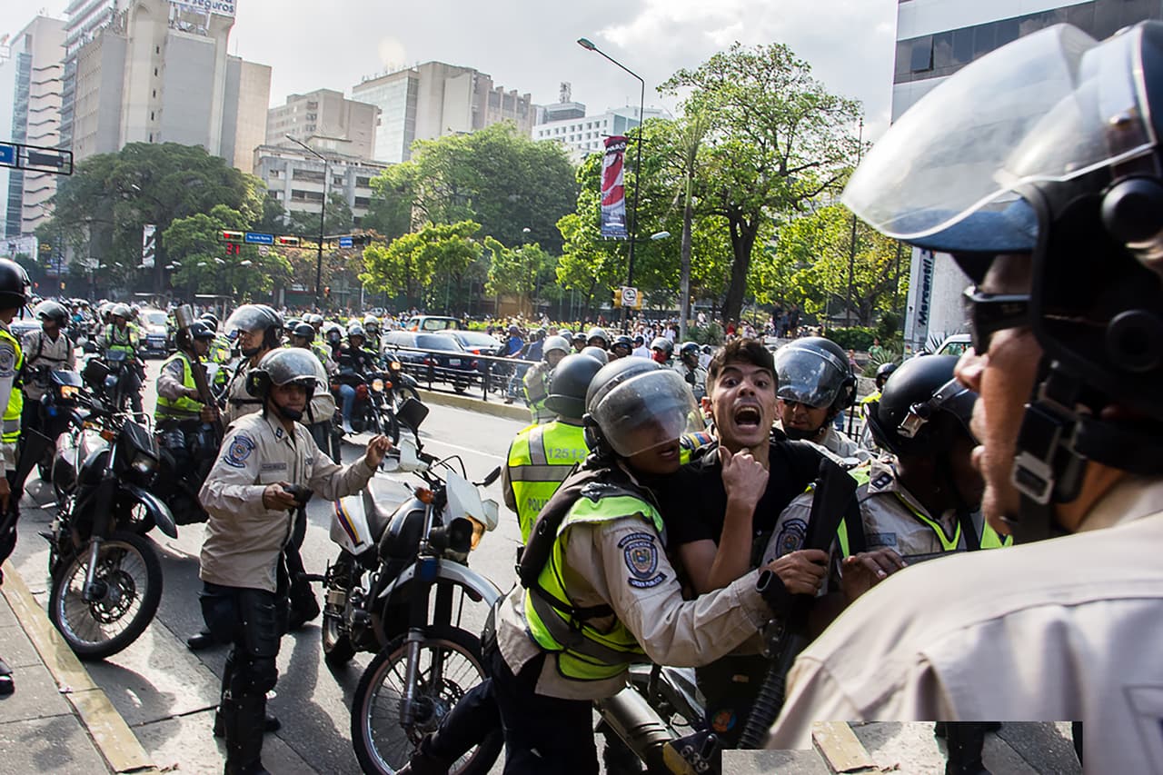 Un manifestante es arrestado por la policía antidisturbios.