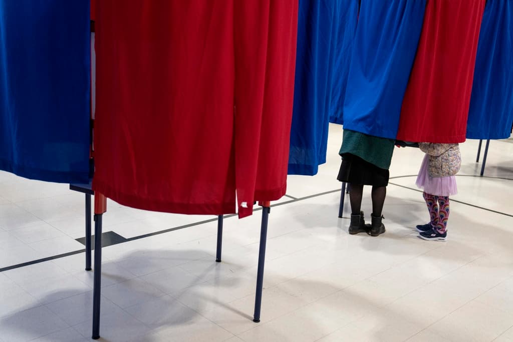 Kara Simard, izquierda, vota con su hija, Violet, de 5 años, en las primarias presidenciales de New Hampshire en un centro de votaciones en Manchester, Nueva Hampshire, el martes 23 de enero de 2024.