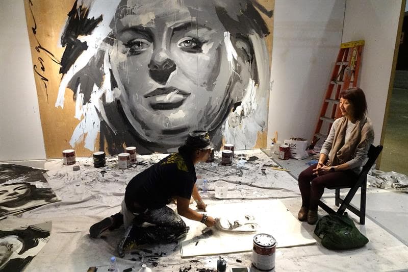 El artista trabaja en un retrato de una mujer.