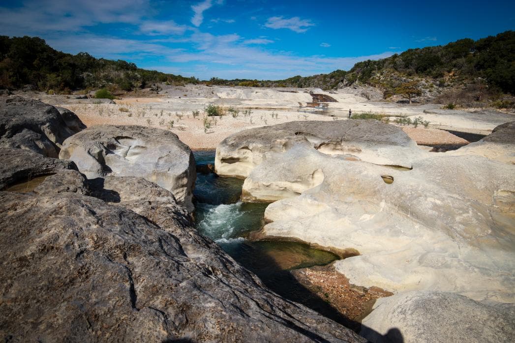 En las tierras altas al norte y al sur del río Pedernales, se puede encontrar piedra caliza marina que contiene fósiles.