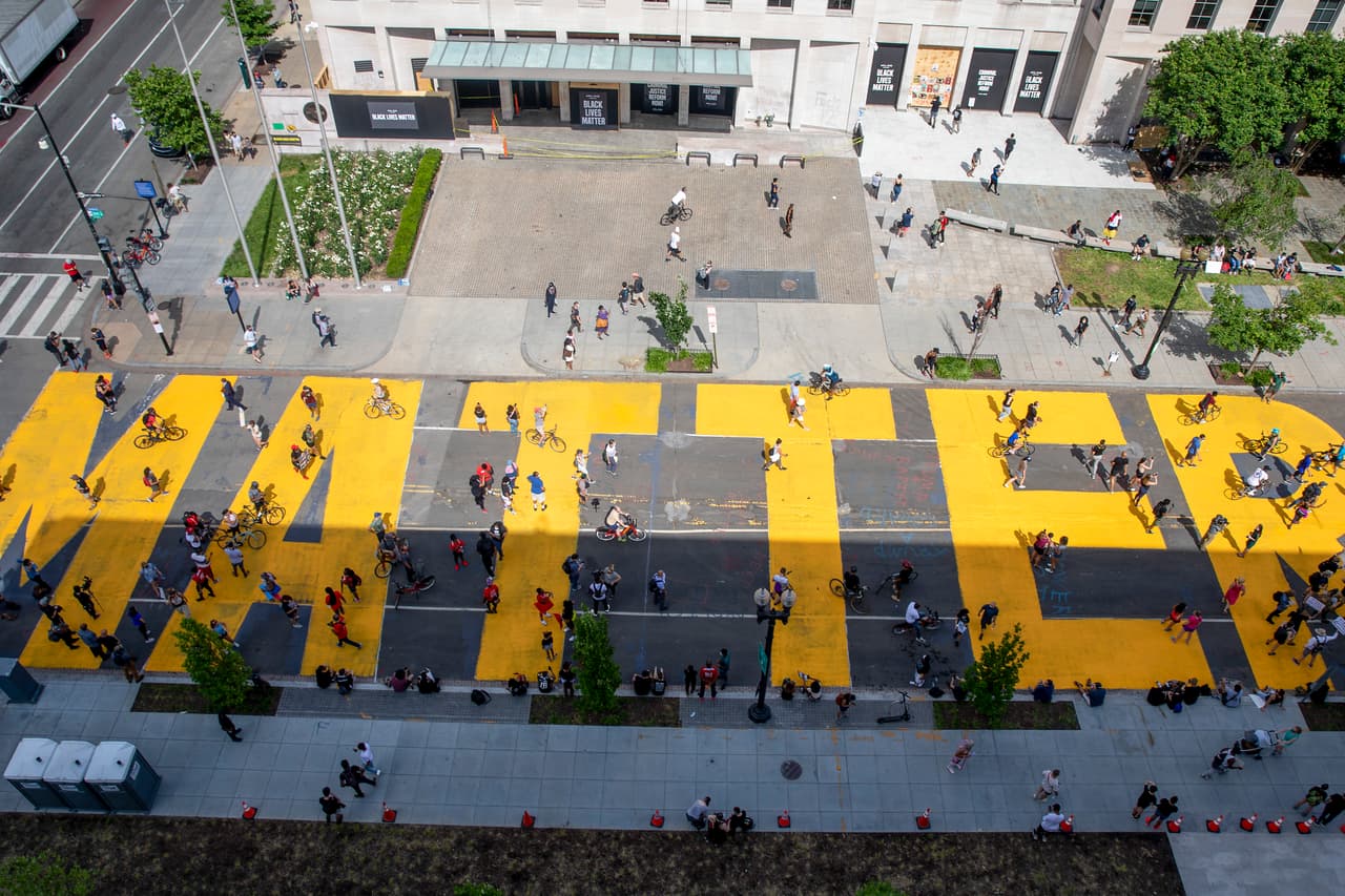 Manifestantes protestan pacíficamente sobre la calle 16, una vía en el corazón de Washington DC que conduce a la Casa Blanca. Un tramo de esta calle tiene ahora el nombre ‘Black Lives Matter’ (‘las vidas de los negros importan’, en español) y este mensaje fue pintado con enormes letras amarillas y brillantes.