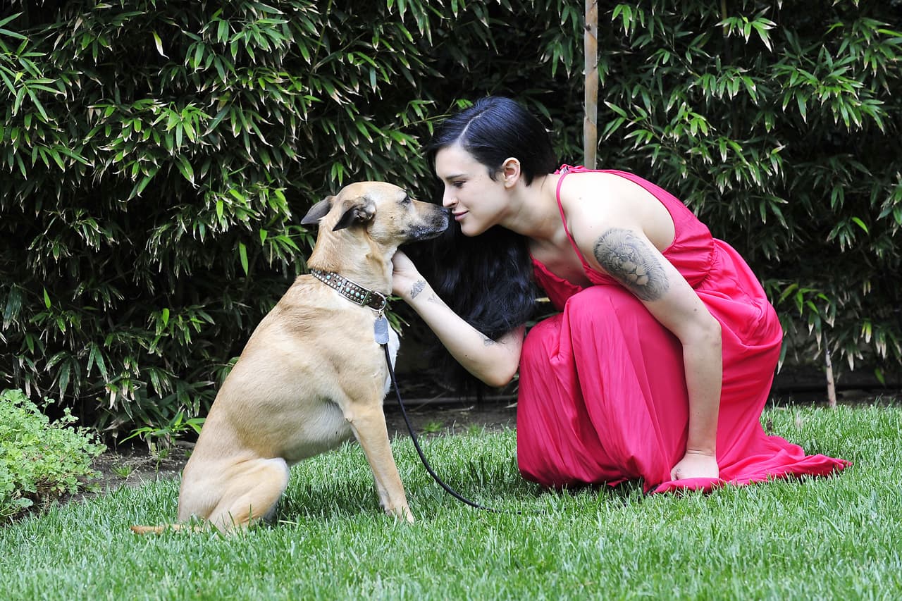 Con un vestido rojo de Calypso St. Barth, la joven se puso a jugar con su mascota.