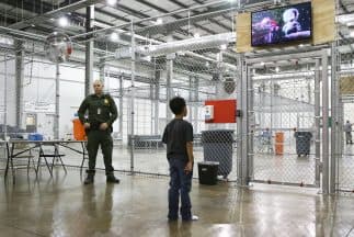 Un niño migrante indocumentado mira una película en un centro de detención provisional de la Patrulla Fronteriza en Texas.