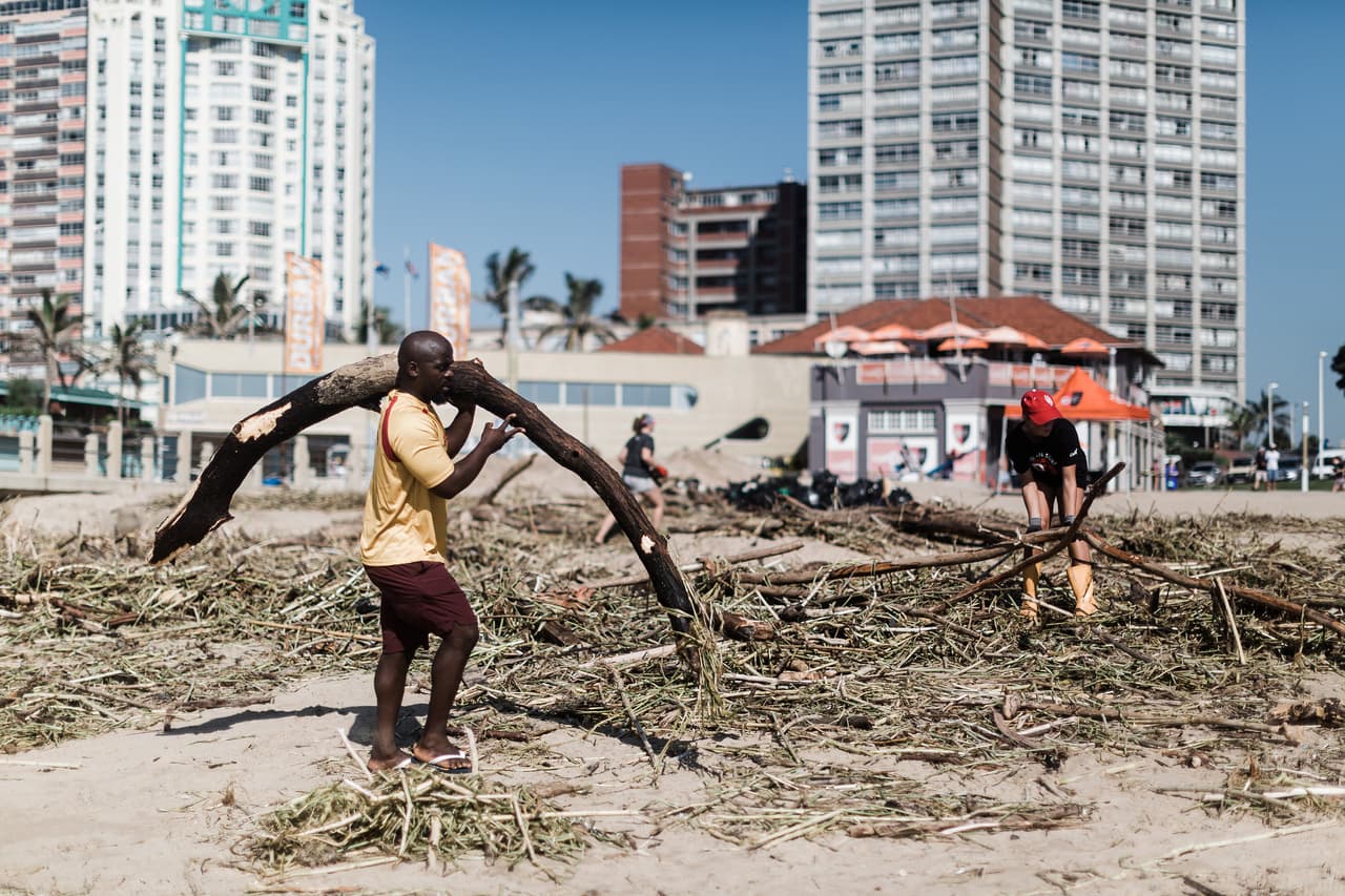 Voluntarios limpian los escombros masivos en North Beach, en Durban. Tras un corto respiro, "los daños siguen acumulándose con la lluvia de hoy que agrava la situación en las zonas afectadas", explicó a la AFP Shawn Herbst, de la empresa de primeros auxilios Netcare 911.
<br>
<br>