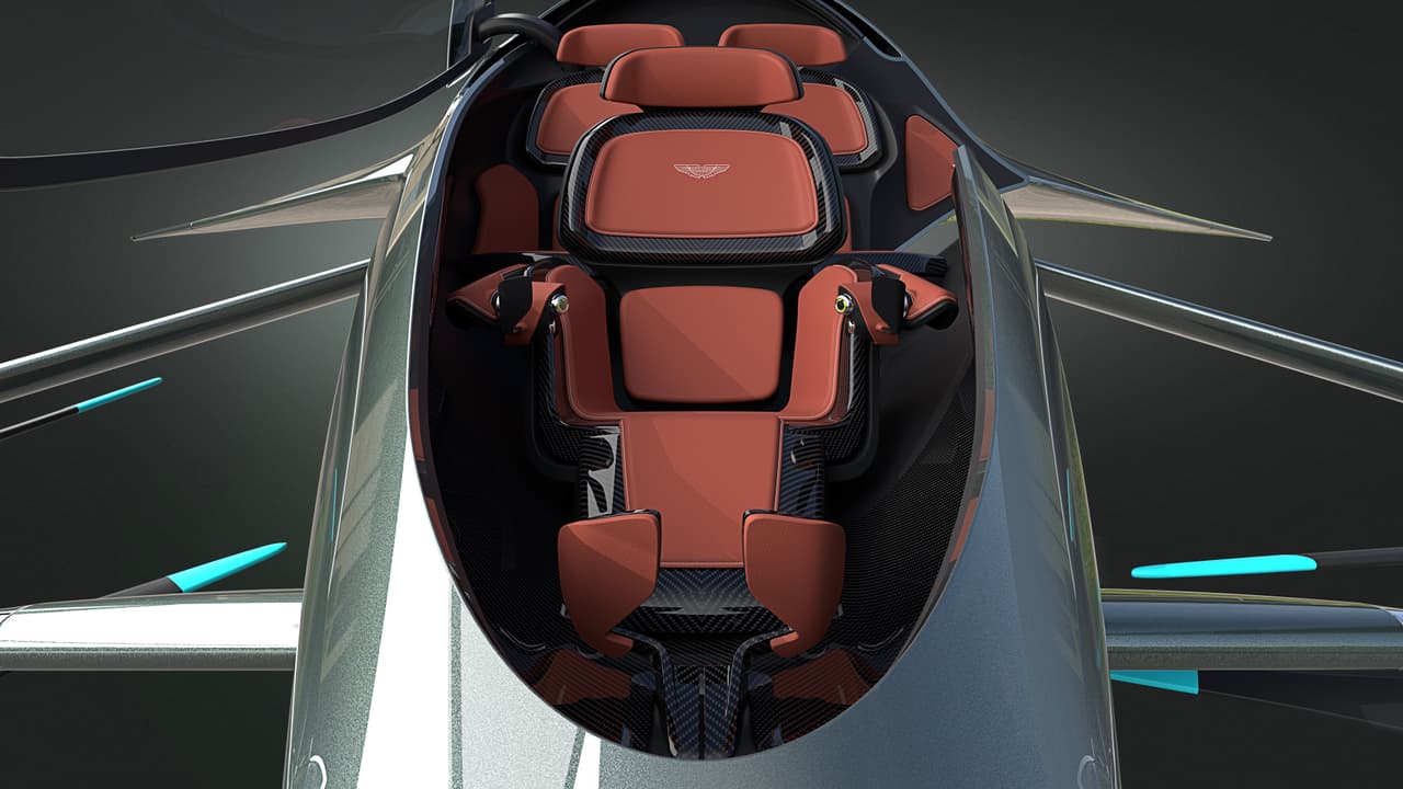 La cabina del Aston Martin Volante Vision Concept no luce particularmente espaciosa. Sus asientos colocados en forma de V, con
<b>un pasajero en la parte delantera y dos atrás</b> recuerda al del McLaren F1 de 1993, pero con las diferencias de que los pasajeros laterales están aún más atrás en este Aston Martin volador, y de que el pasajero delantero no va a estar en control del vehículo, el cual cuenta capacidad de conducción autónoma.