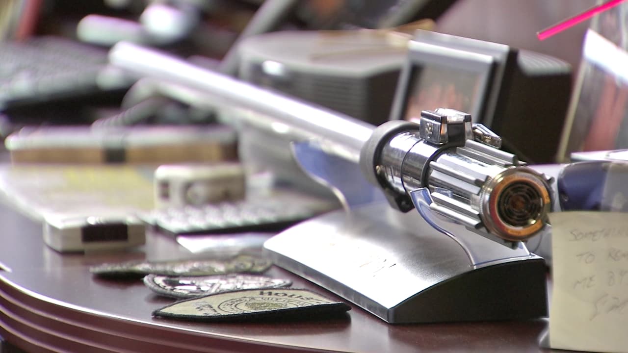 El sable de luz de Star Wars, de color rojo como la que usa Darth Vader en las películas, ocupa un lugar destacado en uno de los escritorios que rodean el puesto de trabajo del jefe Acevedo.