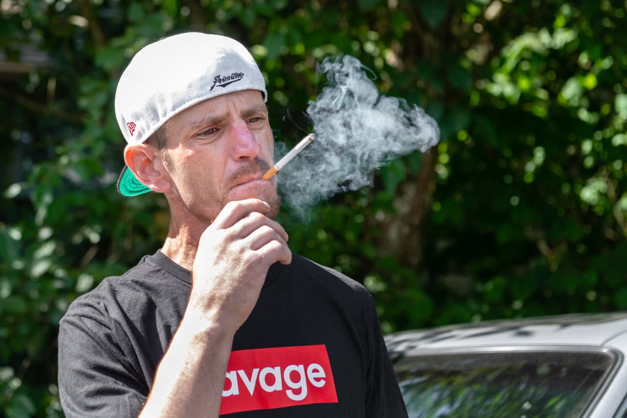 Jimmy Sullivan smokes a cigarette after spending the night in his car. The bricklayer says he had been living in his two-door Honda Accord for weeks. (Heidi de Marco/KHN)