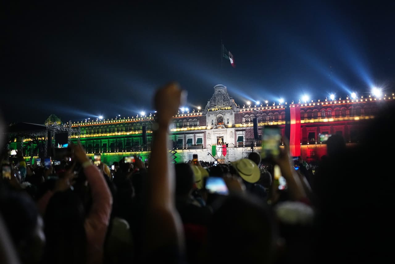 La presidenta Claudia Sheinbaum encabeza el tradicional Grito de Independencia desde el balcón de Palacio Nacional, mientras asistentes reunidos en el Zócalo observan la ceremonia.