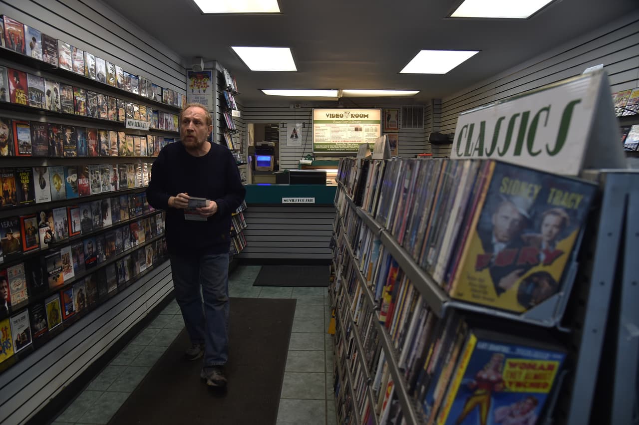 <b>Dependiente de una tienda de videos, Nueva York. </b>Howard, de 67 años, atiende ‘Video Room’, un local que vende y alquila películas y discos en formatos DVD, VHS y LP, entre otros. En la era de Netflix, Hulu y Amazon este establecimiento de Manhattan es uno de los pocos que ofrece películas clásicas o nuevos lanzamientos en formato no digital.