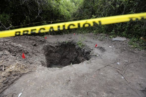 Seis fosas como esta fueron encontradas el sábado por la madrugada a pocos kilómetros de donde desaparecieron los jóvenes.