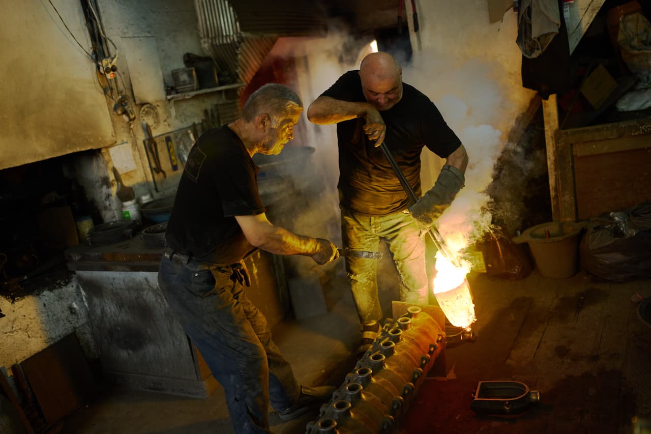Los maestros fundidores de arena Mevlut (izquierda) y Ahmet Yildirim fabrican moldes para verter metal fundido en su taller en el barrio artesanal de Buyukhan en Estambul, Turquía, el jueves 6 de agosto de 2026. (Foto AP/Francisco Seco)