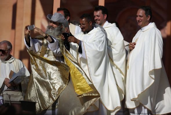 Sacerdotes católicos muestran una imagen del papa Francisco después de la misa que presidió el pontífice en el estadio de Ammán en la capital jordana.