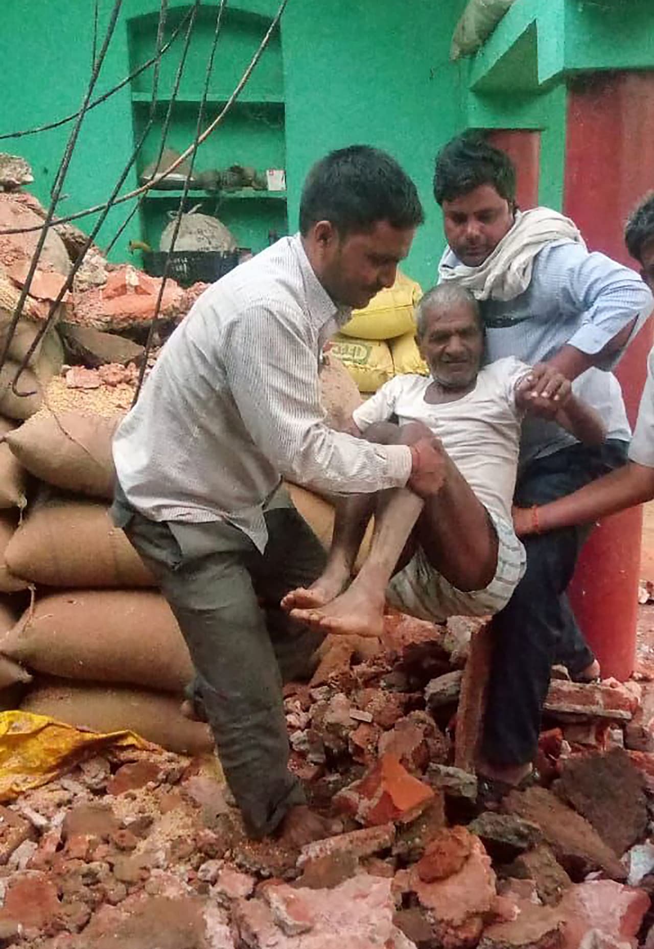 Un hombre es evacuado entre los escombros de su hogar dañado por la gran tormenta de polvo en Etmadpur, Agra, en el estado de Uttar Pradesh.