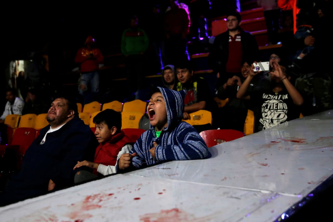 Un niño grita junto a la tarima durante una de las peleas en Arena Neza. A su lado, otro observa con cierto temor el encuentro. Los espectadores suelen gritar y lanzar insultos a los luchadores, que permanecen concentrados en su rival. (Foto e información de Carlos Jasso/Reuters)