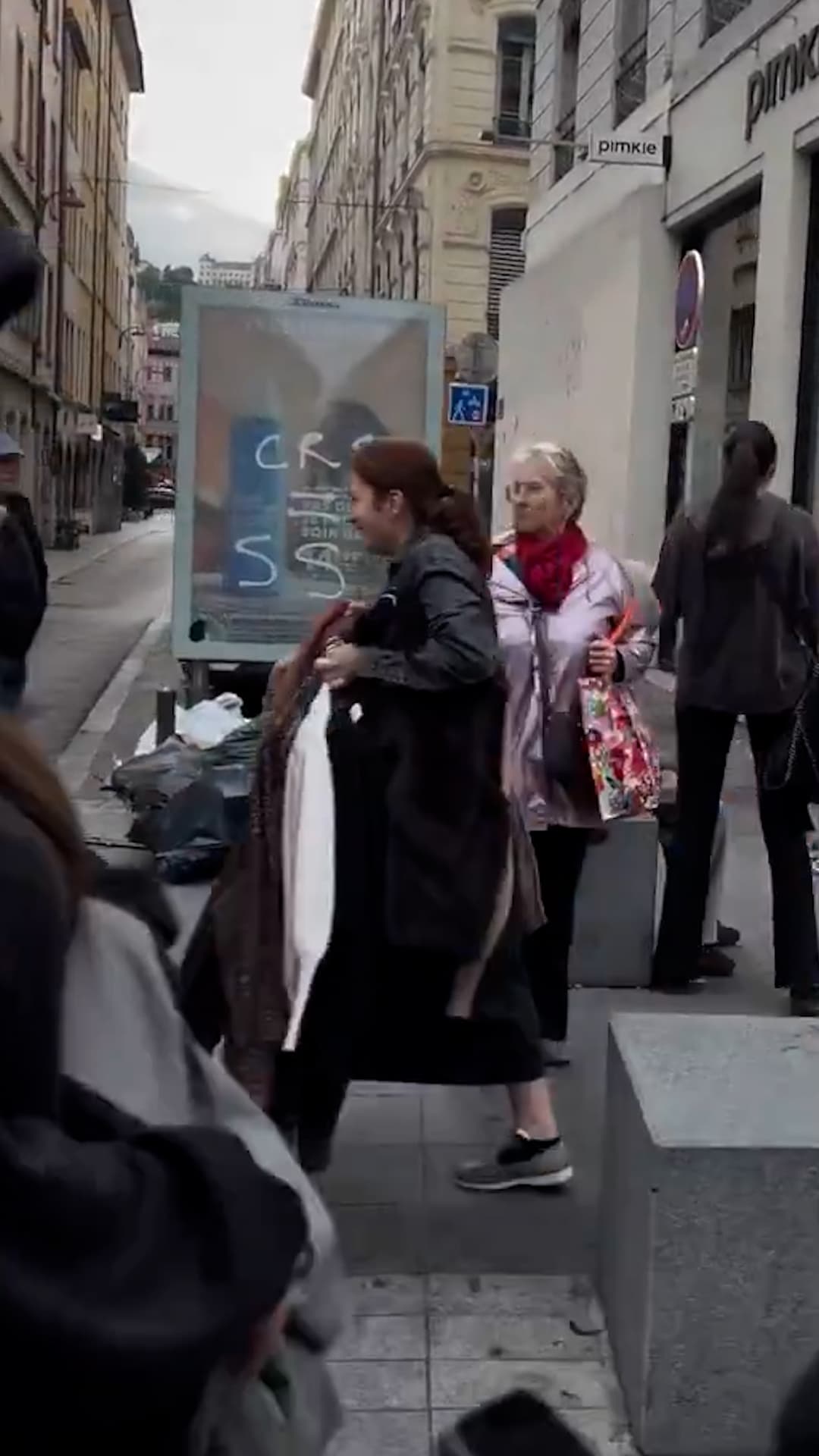 Un hombre obliga a una mujer a regresar ropa robada de una tienda durante los disturbios en Francia