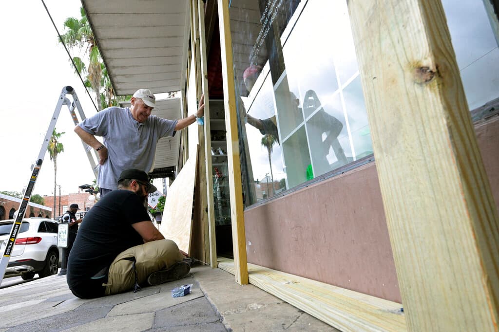 En la foto Carlos Hermida cerrando su negocio en el distrito de Ybor City y preparándolo para resistir el embate de los fuertes vientos.