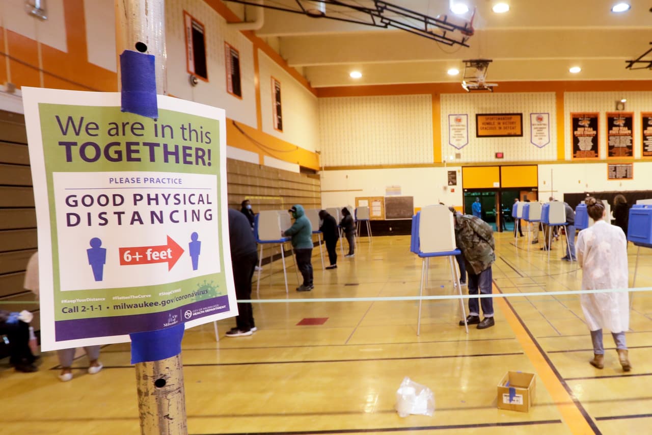 Los votantes practican el distanciamiento social en la secundaria Riverside. Las filas eran particularmente largas en Milwaukee, la ciudad más grande del estado y un bastión demócrata, donde solo cinco de 180 lugares de votación estaban abiertos.