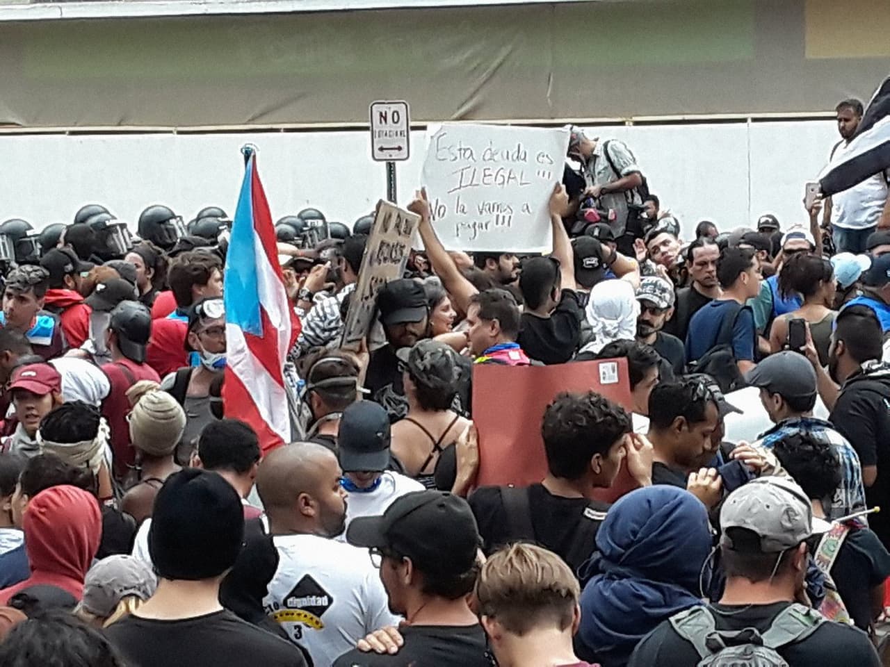 En la foto, los manifestantes se encuentran cara a cara con la policía, que les interrumpió el paso.
<b>Así permanecieron por unas tres horas pacíficamente.</b> (Foto tomada de la cuenta de Twitter del periodista Manuel E. Rivera)