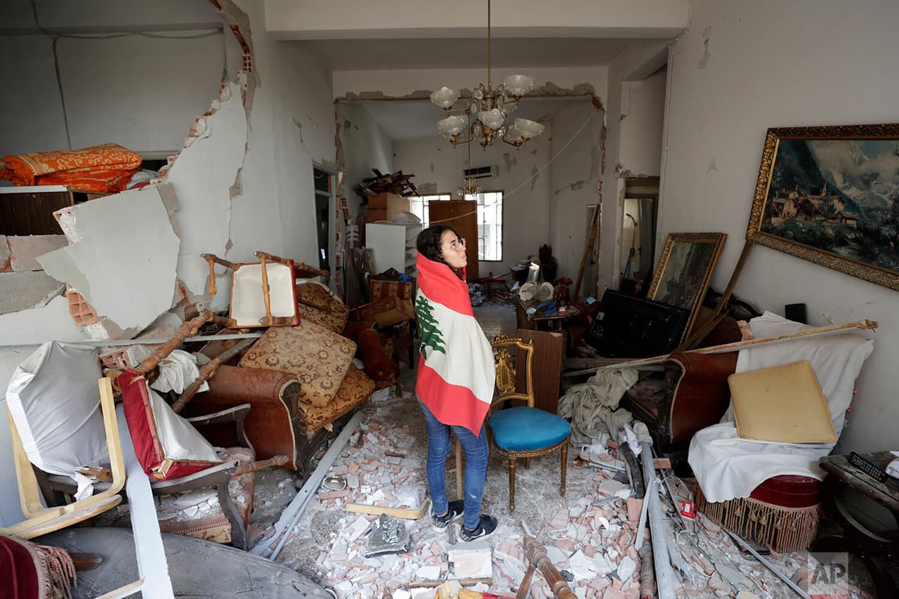 Farah Mahmoud, 
<b>envuelta en la bandera nacional libanesa, revisa el apartamento destruido de sus padres</b> después de la 
<a href="https://www.univision.com/temas/explosiones">explosión</a> en el puerto marítimo de Beirut. Farah mira con nostalgia una de las paredes, donde sigue un cuadro que resistió al impacto, mientras el resto de la casa se puede ver con graves daños estructurales.