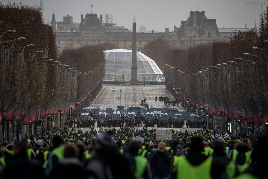 Los manifestantes se dirigen en masa hacia el cuerpo de policía apostado para contener la manifestación en los Campos Elíseos de París.