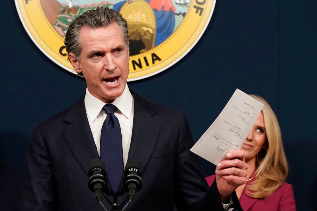 El gobernador de California, Gavin Newsom, muestra un proyecto de ley que acaba de firmar que protege a los proveedores de servicios de aborto y a los voluntarios en California.