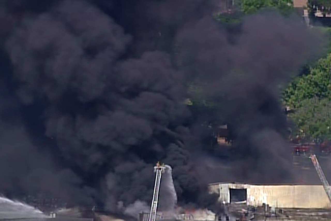 Los valientes bomberos apenas pueden distinguirse en frente de la monumental nube de humo.