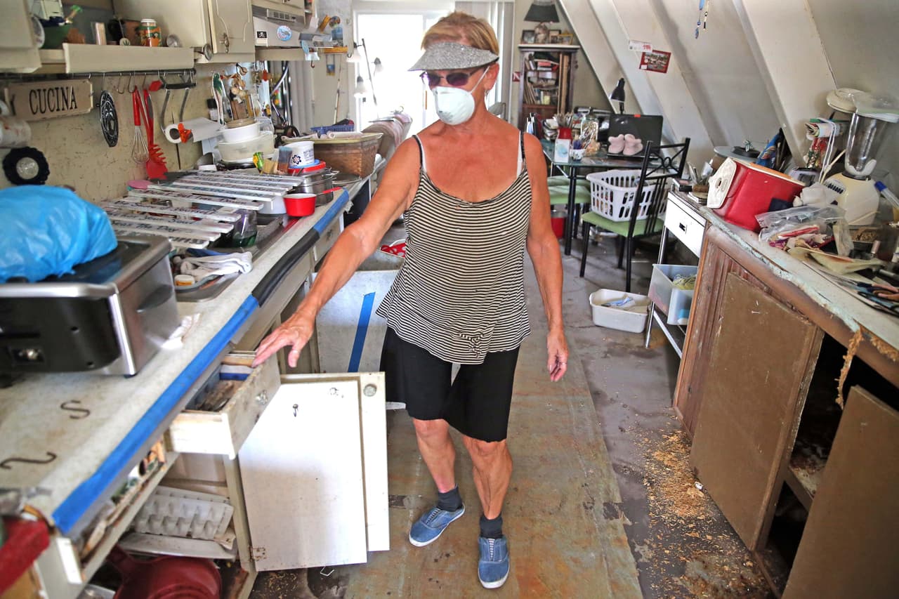 Un mes después del paso del huracán Irma, Dee Thorne camina en la cocina de su casa en Big Pine Key, en los Cayos de Florida. Thorne tiene que llevar una máscara para protegerse del moho tóxico que creció. Mientras recibe ayuda para reconstruir su casa, están viviendo en una especie de trailer en el patio.