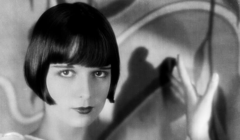 <b>Louise Brooks. </b>Se le conoce como la 
<a href="http://www.mujeresenlahistoria.com/2013/07/la-vampiresa-muda-louise-brooks-1906.html">vampiresa</a> del cine mudo. Posiblemente su apariencia, a medio camino entre lo atrevido y lo 
<i>naif</i>, habrá influido para ganarse este apelativo. La atrevida actriz marcó una época al ser la primera en llevar el corte a la 
<i>garçonnes</i>,
<i> </i>que más adelante se convertiría en símbolo de la emancipación femenina. Sus oscuros labios en forma de corazón marcaron tendencia colaborando a definir el estilo estético de esa época.
<br>