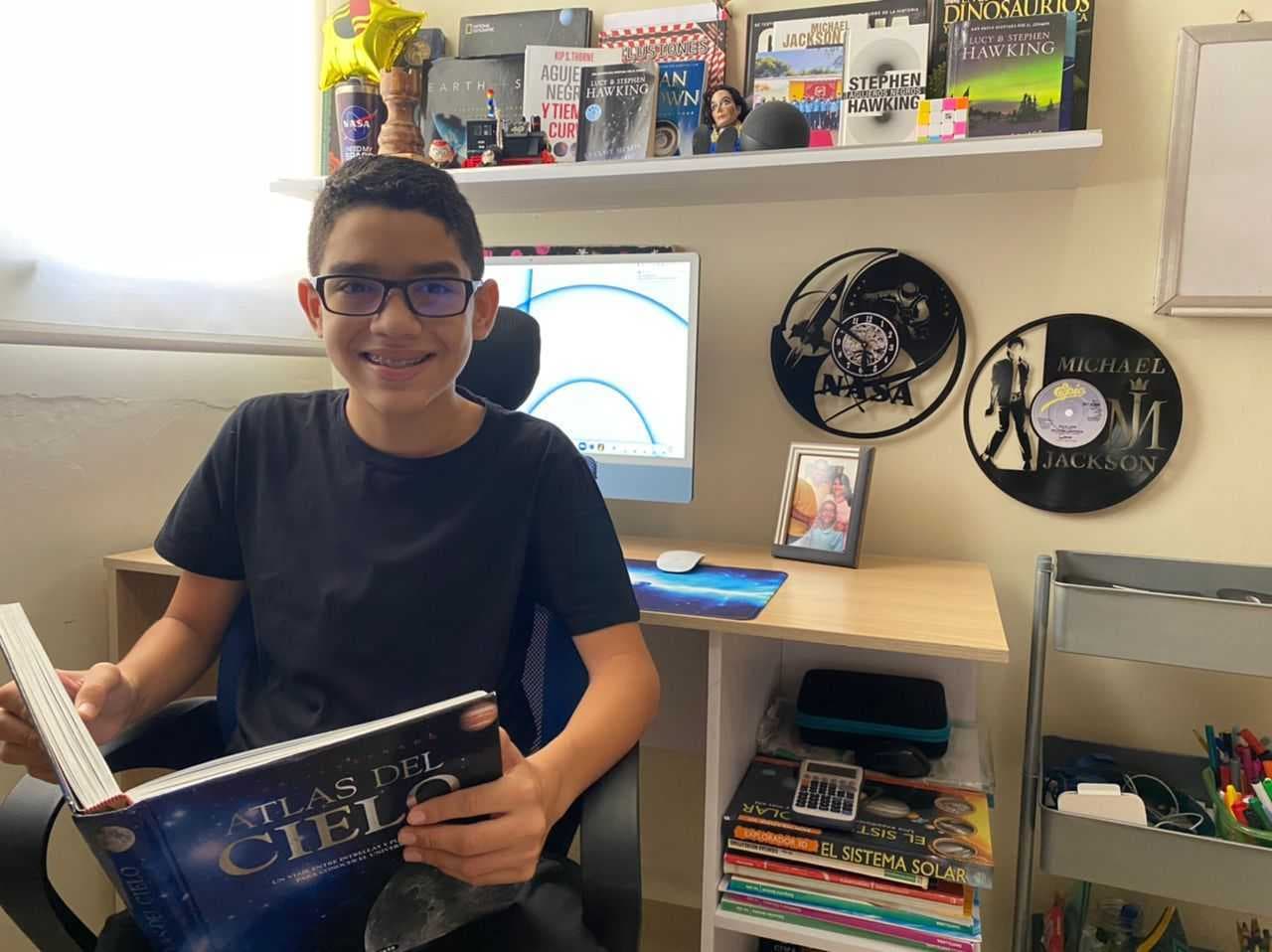 Miguel posa con un tomo del "Atlas del Cielo", uno de sus primeras lecturas sobre el espacio cuando apenas tenía 4 años de edad.