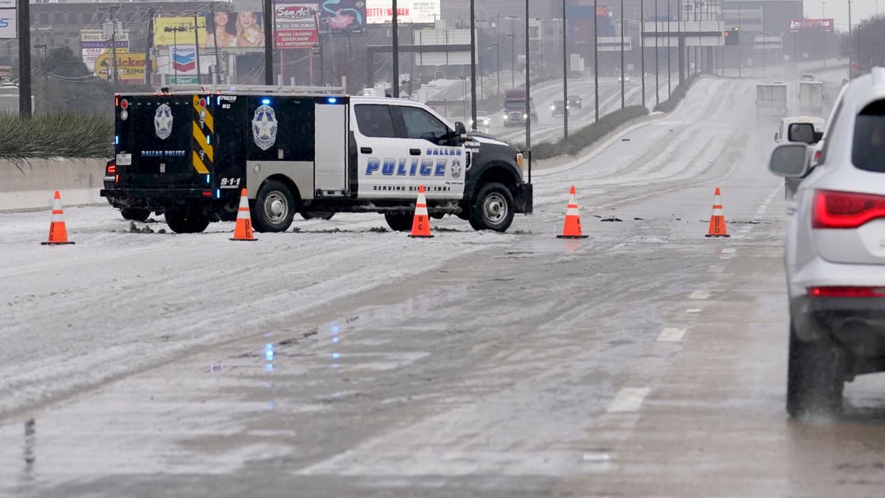 Un vehículo de emergencia de la ciudad de Dallas bloquea los carriles de la autopista 75, durante las condiciones de hielo y aguanieve de la carretera, el miércoles 1 de febrero de 2023.