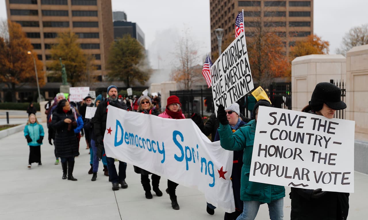 Ciudadanos estadounidenses se manifiestan afuera del Capitolio Estatal de Georgia, antes del encuentro de los dieciséis electores del estado, que emitirán sus votos este 19 de diciembre de 2016. El Colegio Electoral de EE.UU se reúne este lunes para certificar la victoria del republicano Donald Trump.