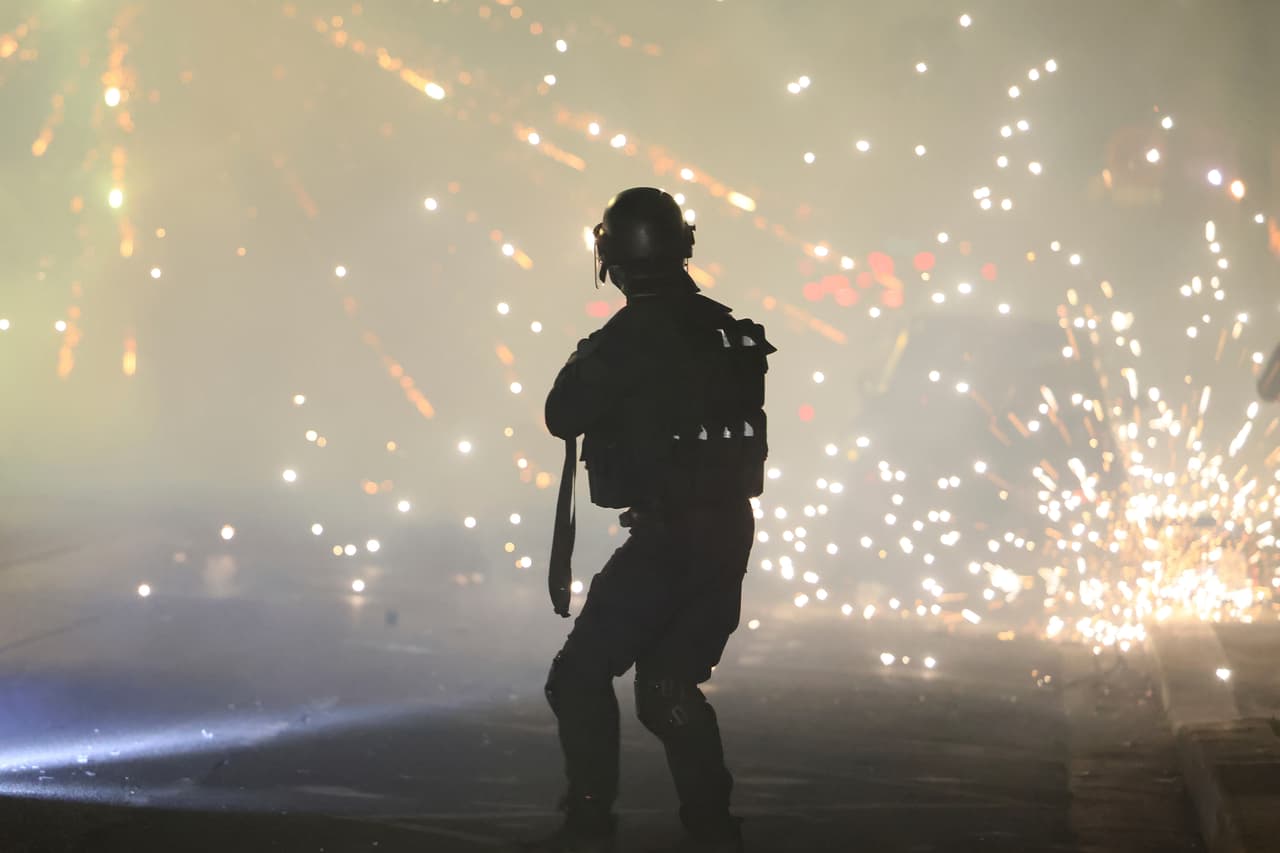 La policía intenta dispersar a aficionados del PSG que lanzaron fuegos artificiales durante las celebraciones por el título de la Liga de Campeones en París.