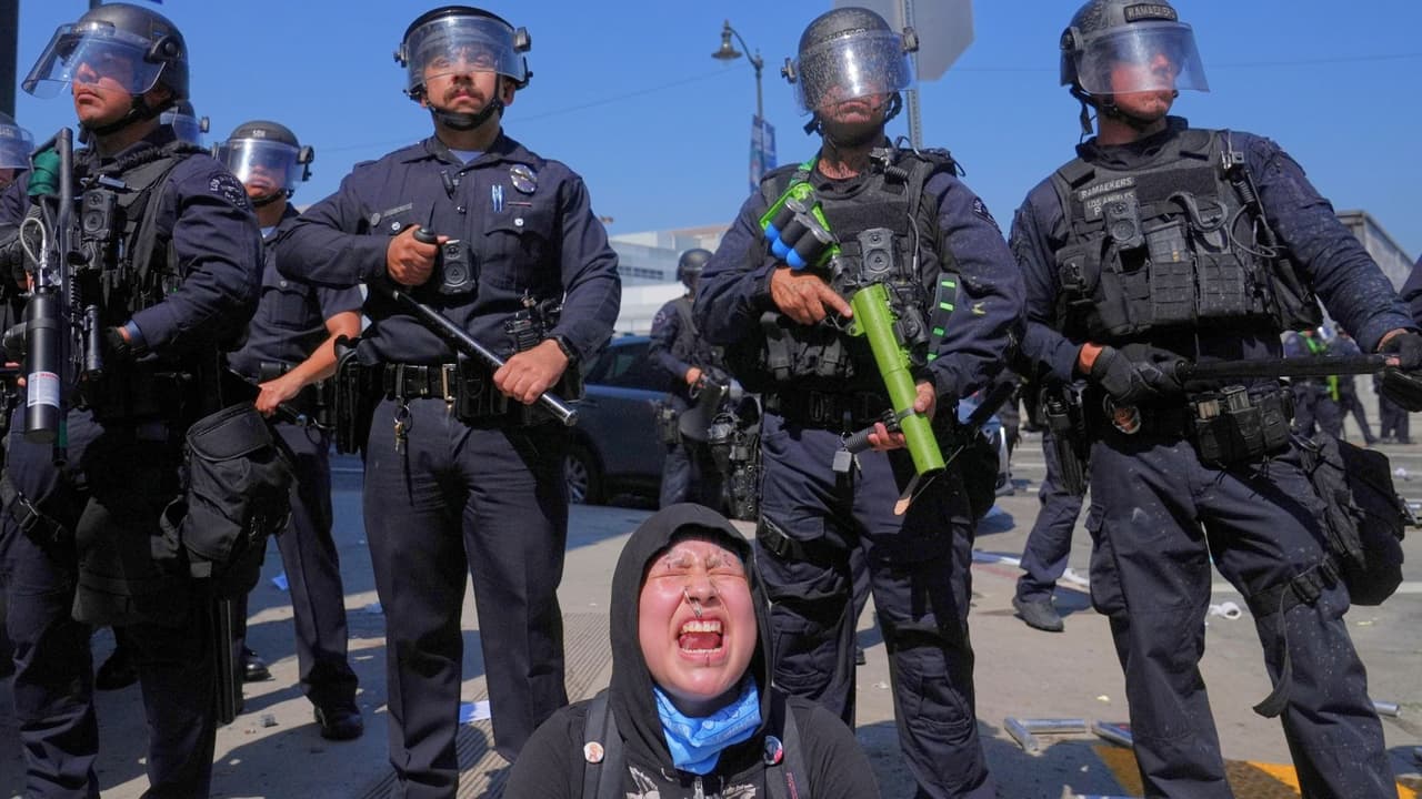 Maribel Parra grita mientras los manifestantes se enfrentan a una fila de policías cerca del centro de detención metropolitano del centro de Los Ángeles, el domingo 8 de junio de 2025, tras la protesta de la redada de inmigración de anoche.
