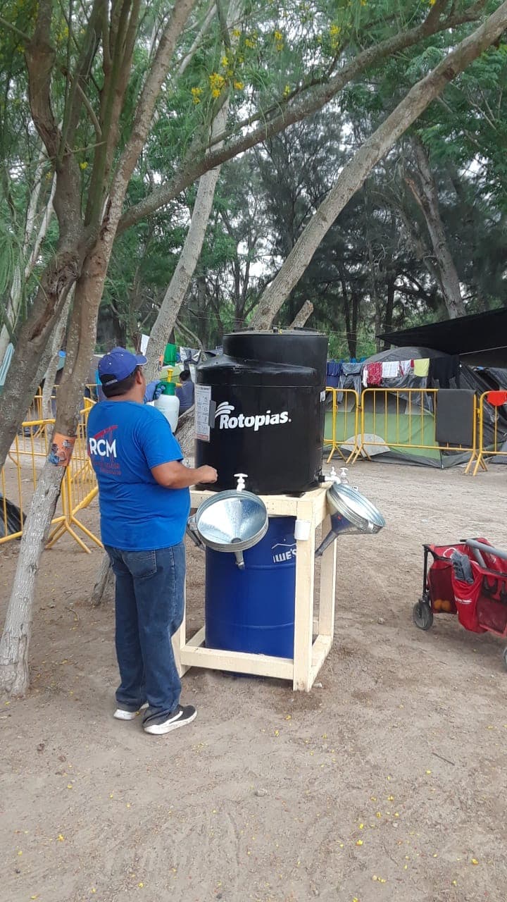 Un voluntario llena agua en una de las estaciones habilitadas por la organización no gubernamental GRM.