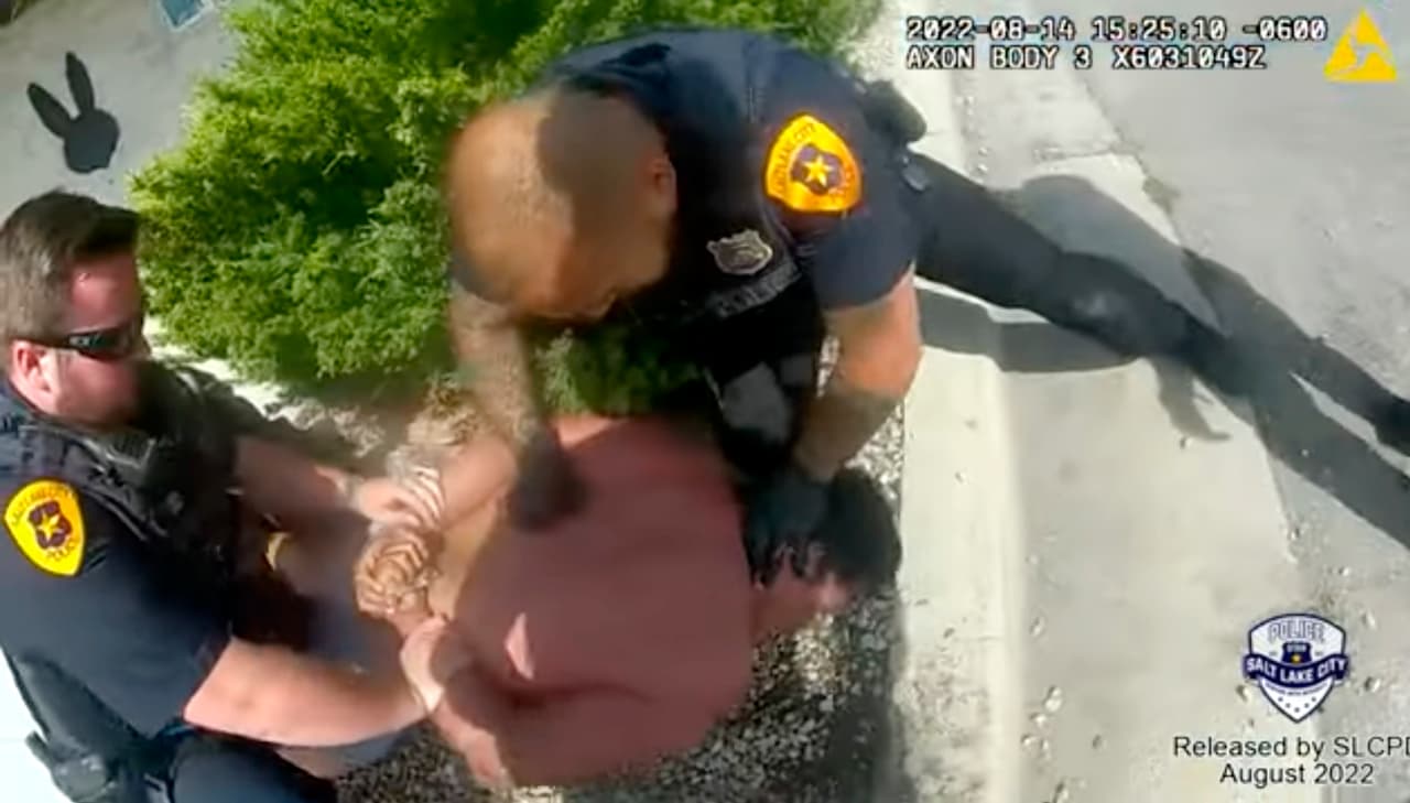 Esta imagen tomada de una cámara de video corporal de un policía, proporcionada por el Departamento de Policía de Salt Lake City el viernes 26 de agosto de 2022, muestra a agentes de policía tratando de someter a Nykon Brandon en una calle de Salt Lake City, el domingo 14 de agosto de 2022.