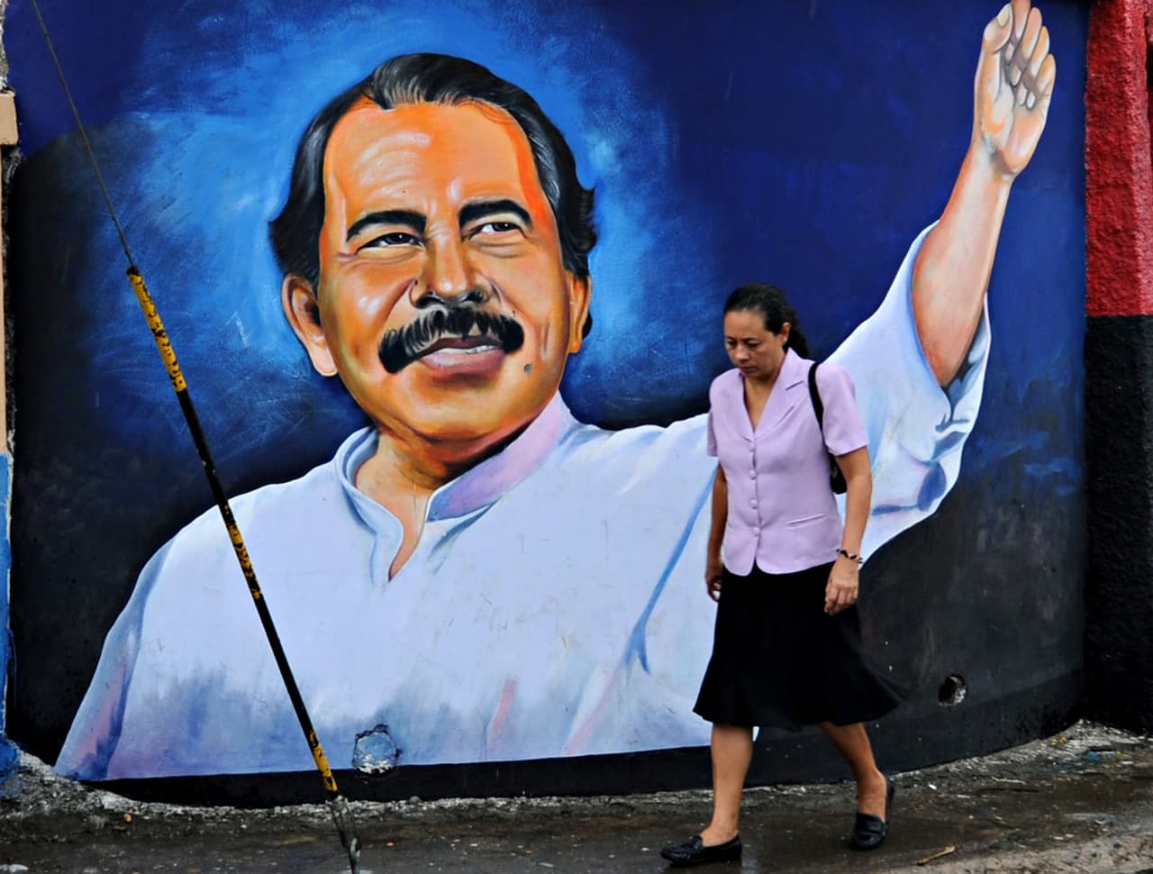Una mujer pasea frente a un mural de Daniel Ortega en Managua.