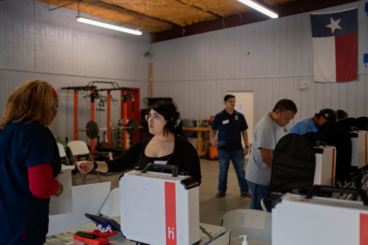 En la fotografía se observa a María Rivera, empleada electoral, mientras entrega una boleta a un votante en la Estación 2 del
<b>Departamento de Bomberos Voluntarios de Westfield Road de la Comunidad de East Aldine en Houston, Texas. </b>
<br>
<br>La carrera presidencial está entre el candidato republicano,
<b>el expresidente Donald Trump, y la candidata demócrata, la Vicepresidenta Kamala Harris, así como en múltiples elecciones estatales que determinarán el equilibrio de poder en el Congreso.</b>