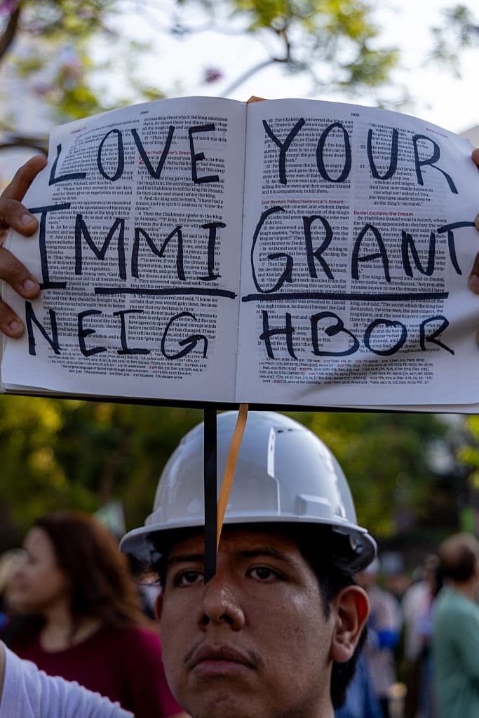 Sin abrir la boca, este joven proclamaba 
<b><a href="https://www.univision.com/local/north-carolina-wuvc/trump-llega-a-la-fiesta-por-los-250-anos-del-ejercito-en-fort-bragg-apuntando-su-mensaje-a-los-angeles-fotos" target="_blank">"Ama a tu vecino inmigrante"</a></b>, en un escrito en las páginas de una biblia, el libro sagrado para los cristianos.