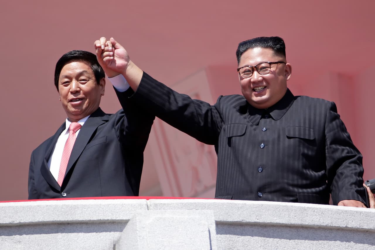 Kim asistió al desfile pero no habló ante la gente ni los invitados, entre los cuales estaban el jefe del parlamento chino y altos delegados de países que tienen lazos estrechos con Corea del Norte. En la imagen, el líder norcoreano Kim Jong Un, derecha, levanta la mano junto con el más alto funcionario chino, Li Zhanshu, durante el desfile.