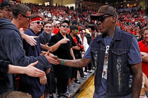 Dennis Rodman, exjugador del Texas Tech, saluda a sus fanáticos con palmadas al llegar a un juego en Lubbock, Texas.