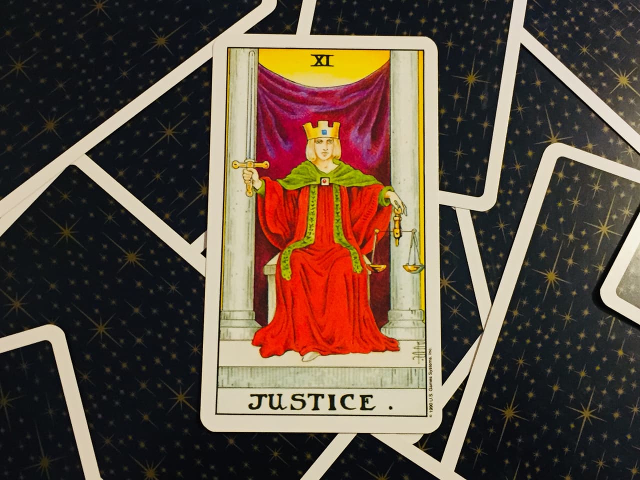 Y es que, como puedes apreciar en su representación icónica más importante, es una dama con una corona, denotando una importante posición social, quizá una reina, que en su mano izquierda sostiene una balanza, el símbolo por excelencia de la búsqueda de la justicia, mientras que con la derecha eleva una espada, mostrando la implacable fuerza con la que se va a castigar - si te lo mereces.