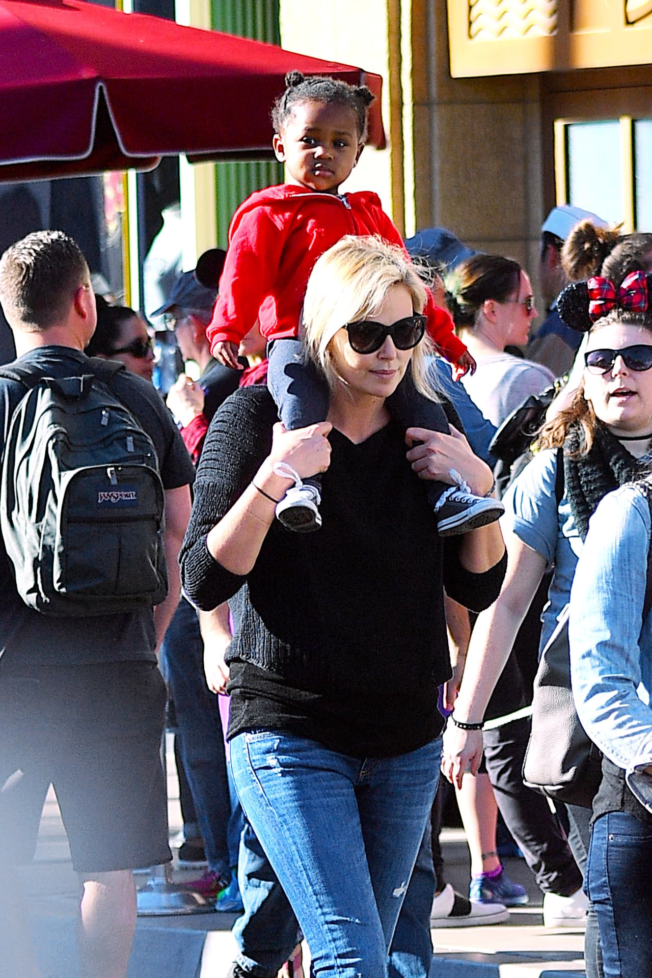 Llevando en sus hombres a la nena August.