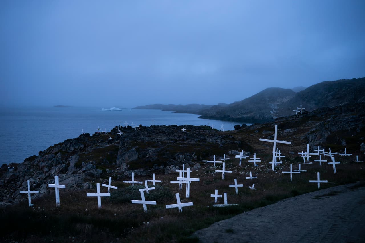 <b>Cementerio y glaciar. </b>Los habitantes del pueblo de Kulusk lamentan que el cambios climático está alterando sus costumbres y hasta los negocios. Los perros para trineos han tenido que dejar de criarse, en parte porque no hay nieves para entrenarlos como antes. En consecuencia no pueden ofrecerle el tradicional servicio a los pocos turistas que llegan a la zona.