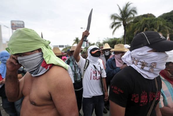 Con la cara cubierta y armados con machetes, bombas incendiarias, picos y palas protestaron porque sigue sin conocerse el paradero de los jóvenes.