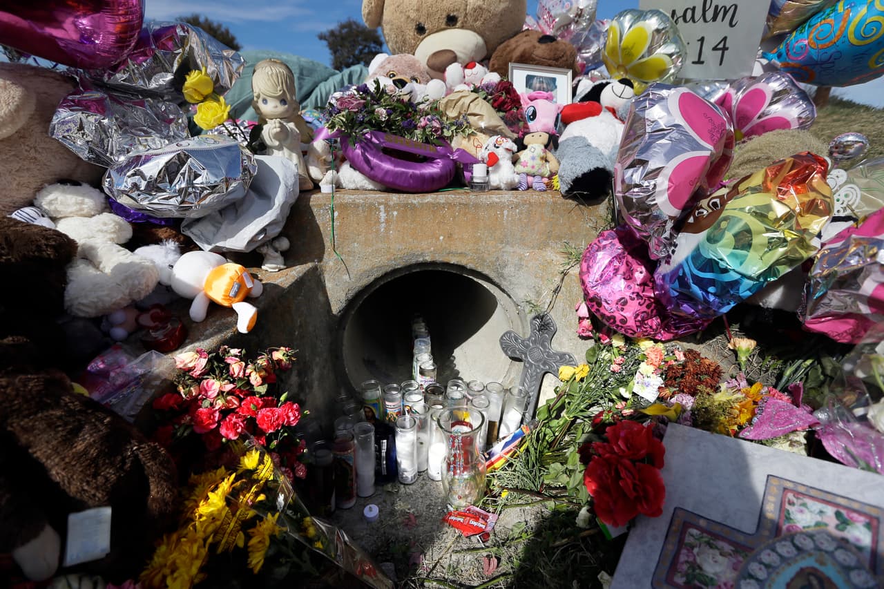 A ditch drain sits enveloped by items left behind at a makeshift memorial for 3-year-old Sherin Mathews, Saturday, Oct. 28, 2017, in Richardson, Texas. A team of volunteer search and rescue dog handlers who helped search for a slain toddler in Texas say the dog that helped find her caught a scent from a long distance and went to an area not scheduled to be searched. (AP Photo/Tony Gutierrez)