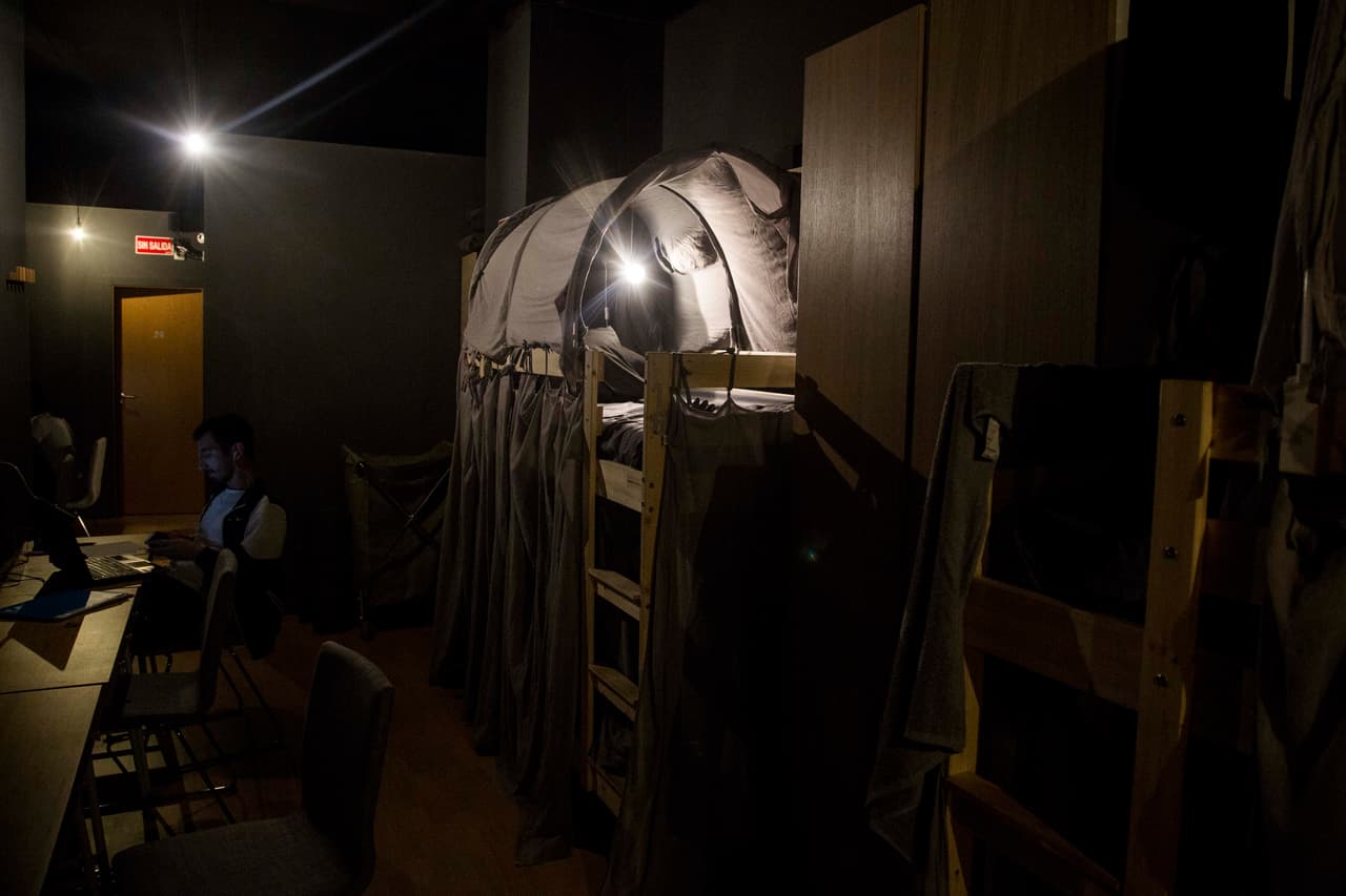 "Se revela una habitación muy oscura. Con literas de madera recubiertas con grises mosquiteras para la selva"