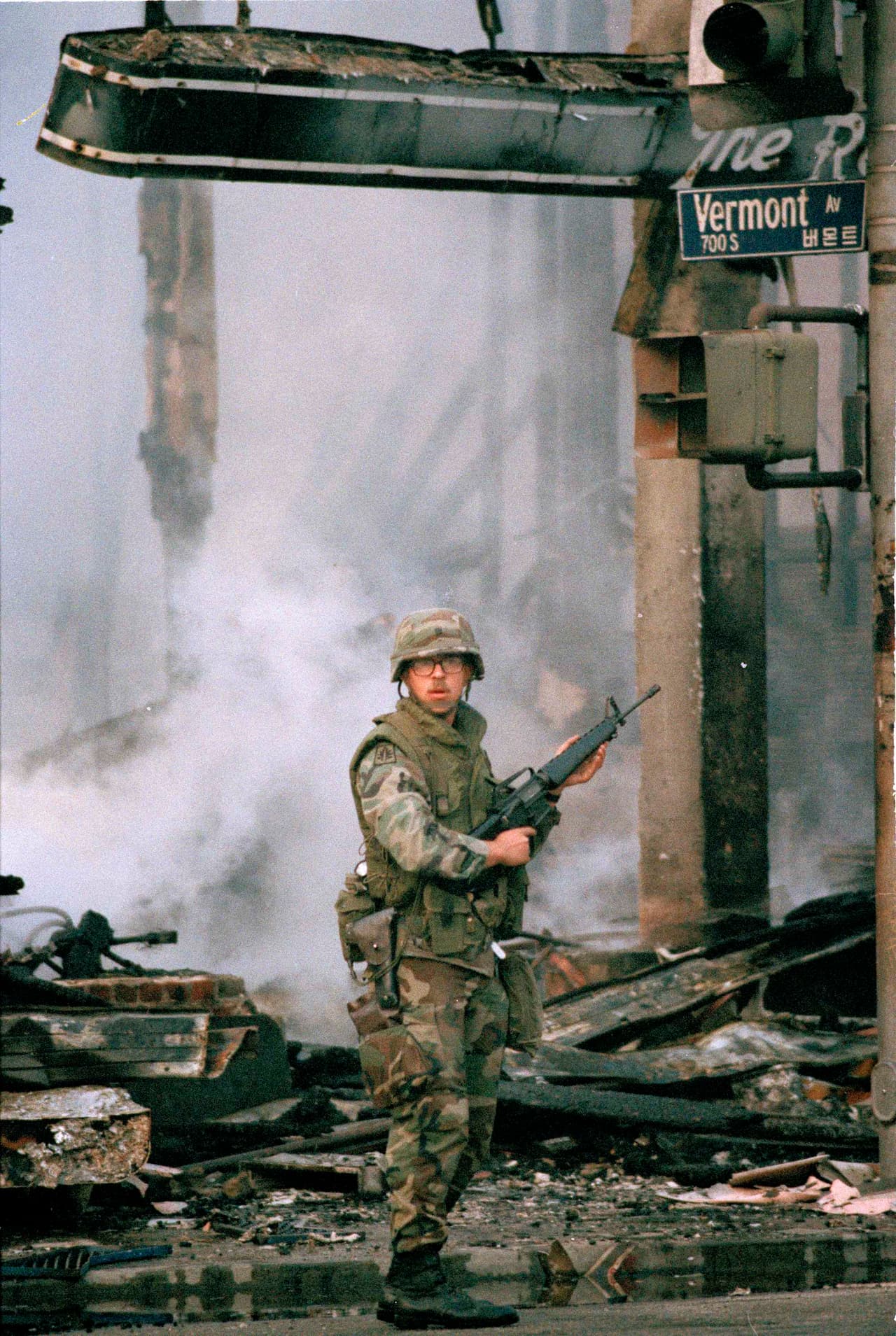 Un elemento de la Guardia Nacional vigila un incendio calcinado en la esquina de la avenida Vermont y el bulevar Wilshire, en el oeste de Los Ángeles, cuando ya iban dos días de incidentes violentos.