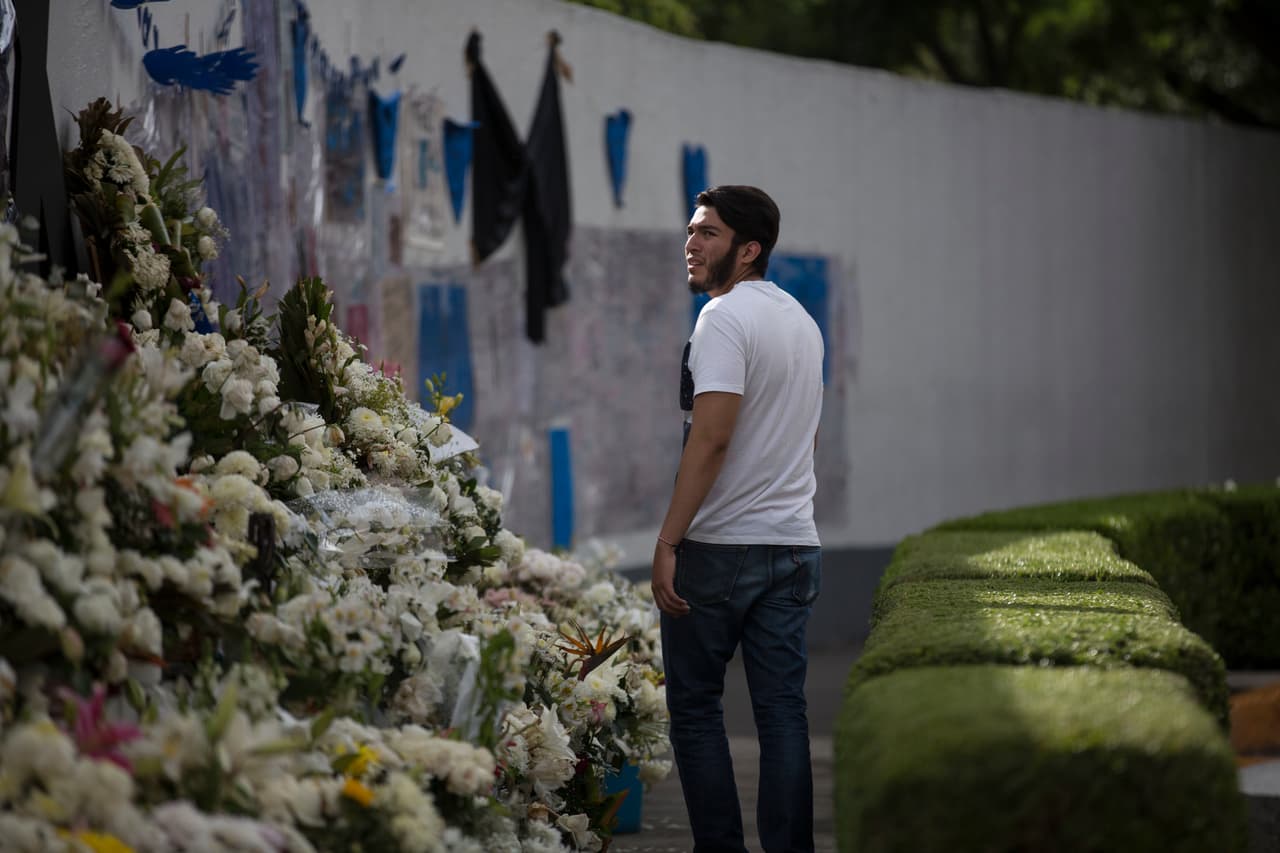 Un hombre visita un altar dedicado a cinco estudiantes fallecidos en un campus universitario al sur de Ciudad de México.