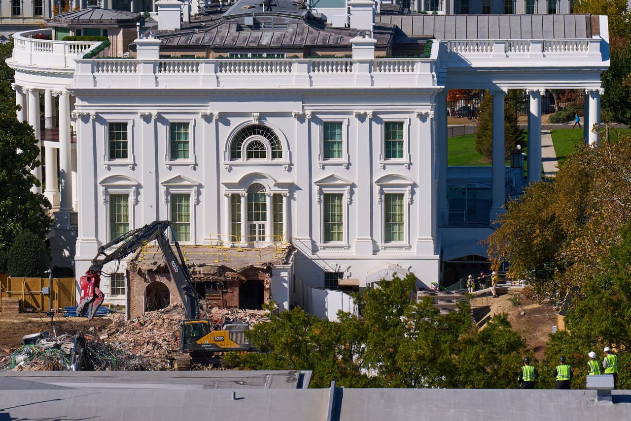 Obreros de la construcción, abajo a la derecha, en lo alto del edificio del Tesoro de Estados Unidos, observan cómo continúan las obras en una parte casi completamente demolida del Ala Este para dar paso a un salón de baile, en la Casa Blanca en Washington, el 23 de octubre de 2025.