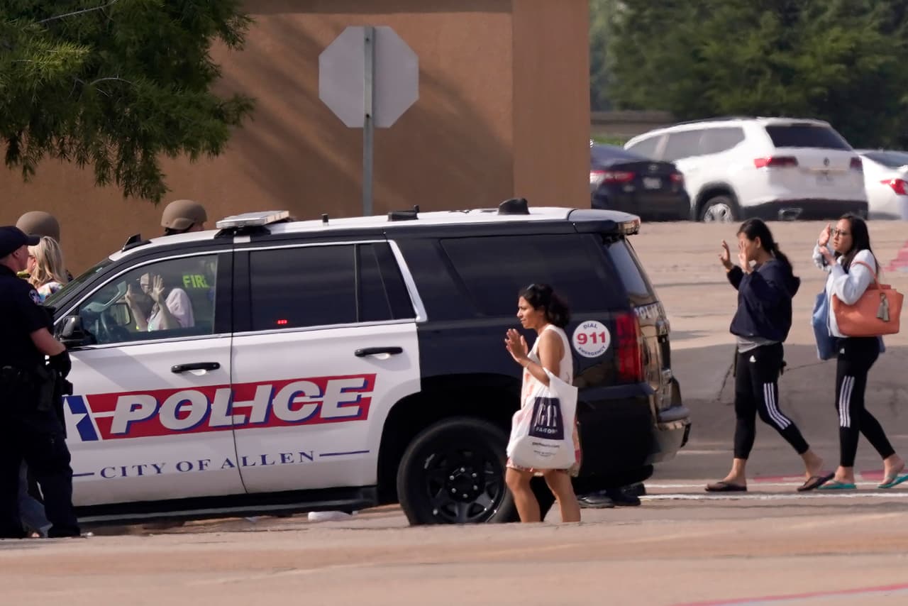 Más personas con las manos levantadas salen del centro comercial Allen Premium Outlets tras los informes de un tiroteo, el sábado 6 de mayo de 2023, en Allen, Texas.